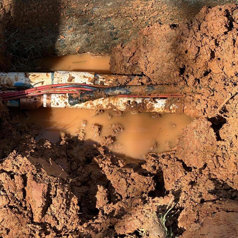 Water line and electrical conduit in muddy excavation site