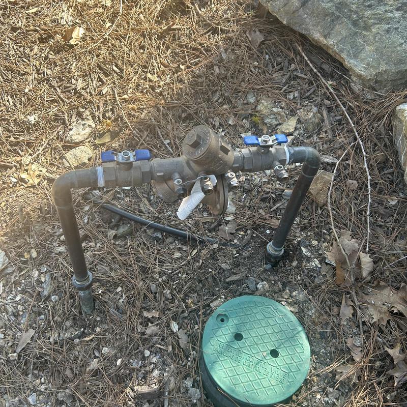 Backflow prevention device with pipe connections outdoors