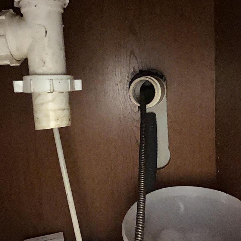 Kitchen sink drain pipe with cleaning snake inserted