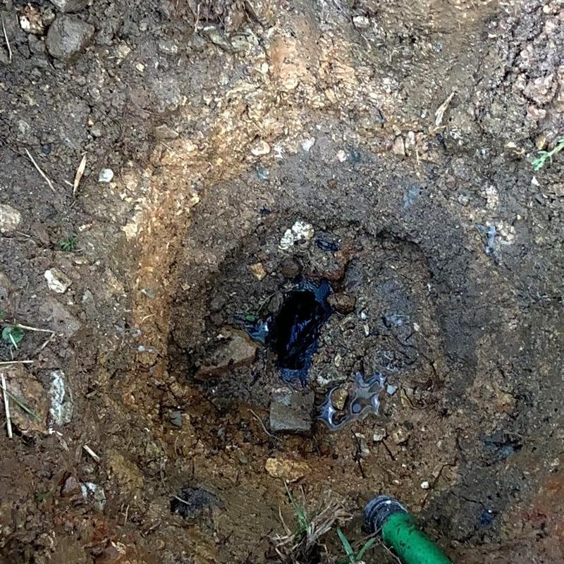 Main sewer line excavation with exposed pipe end