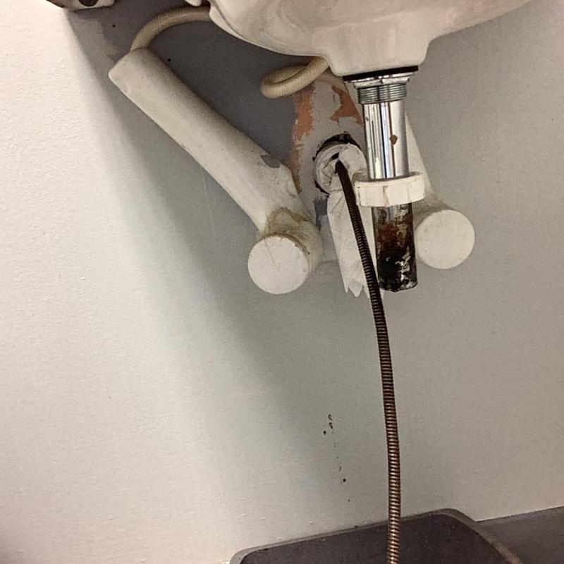 Sink drain pipe with drain snake in men's room