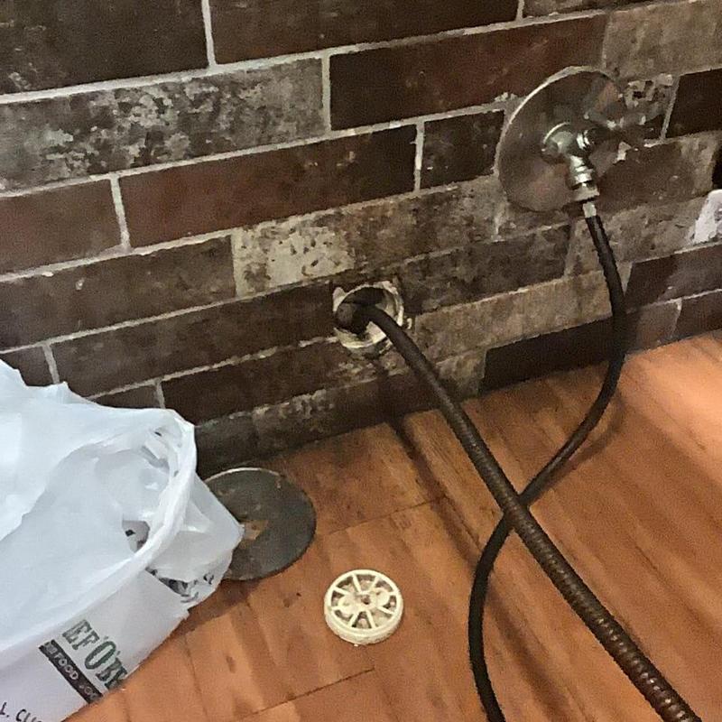 Main sewer line cleaning snake inserted through wall pipe