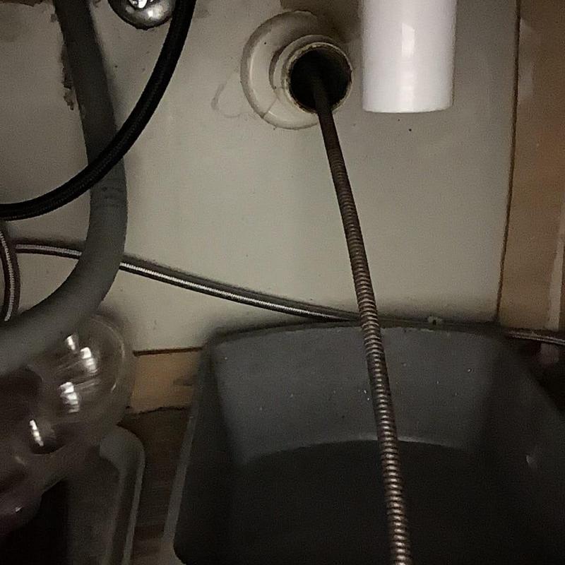 Kitchen sink drain cleaning auger inside drain pipe