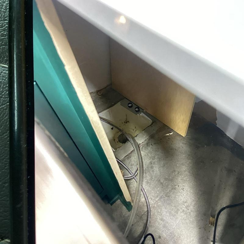 Clear hose installation near floor drain and cabinet base