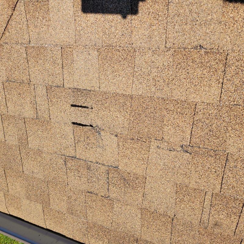 Asphalt shingles with minor damage on roof surface