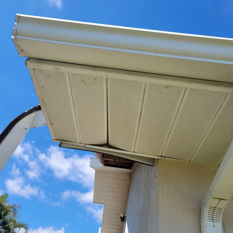 Soffit panels with repaired sections under roof edge
