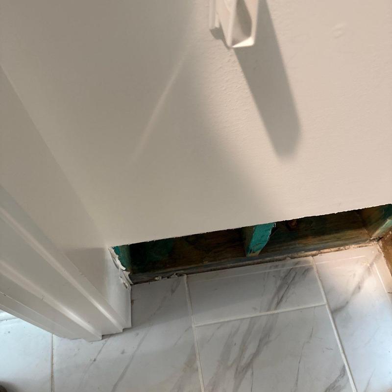 Wall base with exposed framing and tile floor