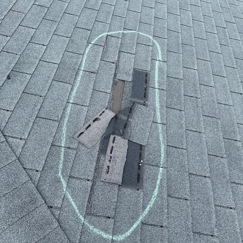 Asphalt roof shingles with damage marked for repair