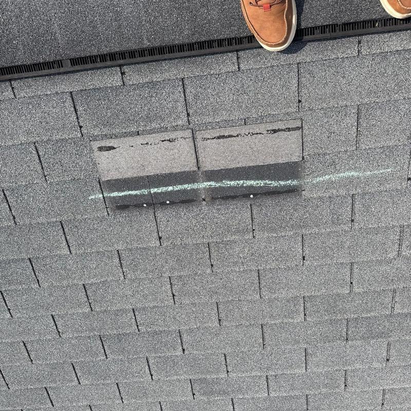 Asphalt roof shingles with chalk-marked damage