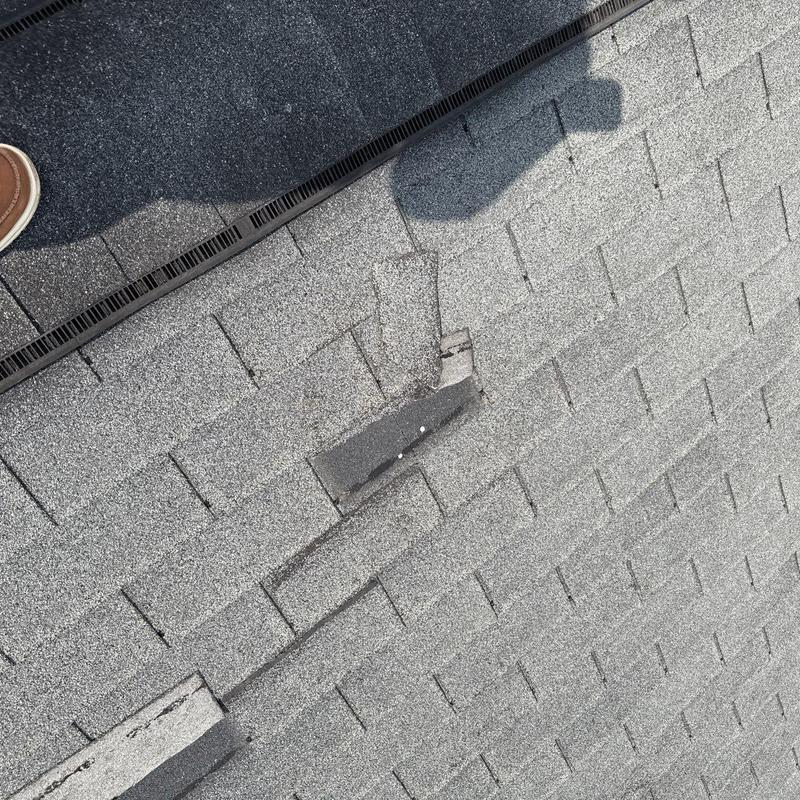Asphalt shingle roof with damaged and missing shingles