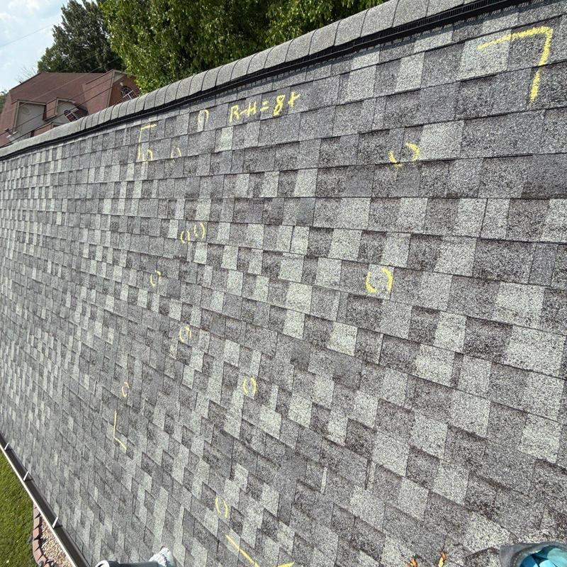 Roof shingles with marked hail damage and granule loss