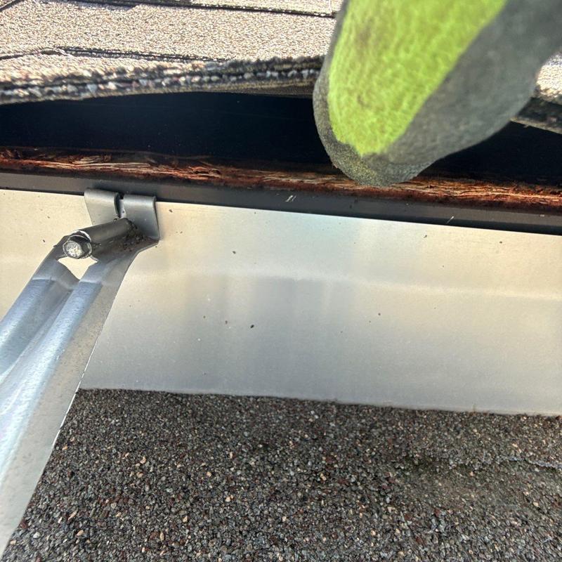 Metal flashing with damaged wood and roof shingles