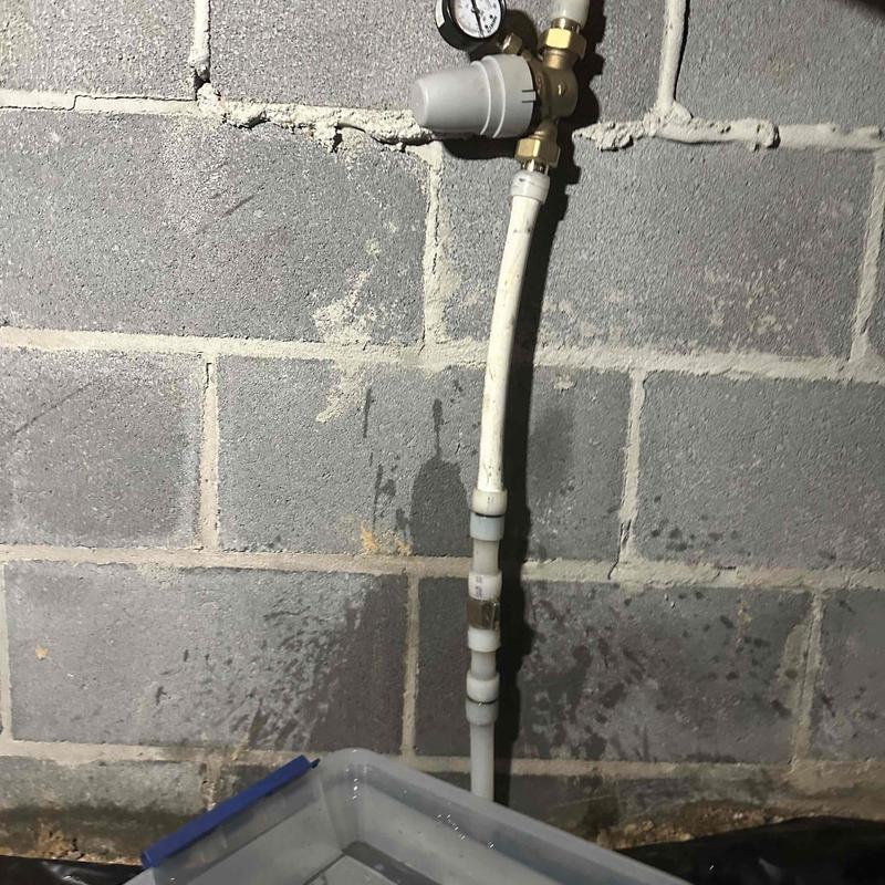 PRV valve pipe with pressure gauge against wall
