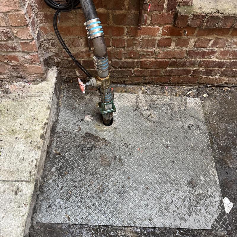 Sump pump discharge piping with valve and cover plate