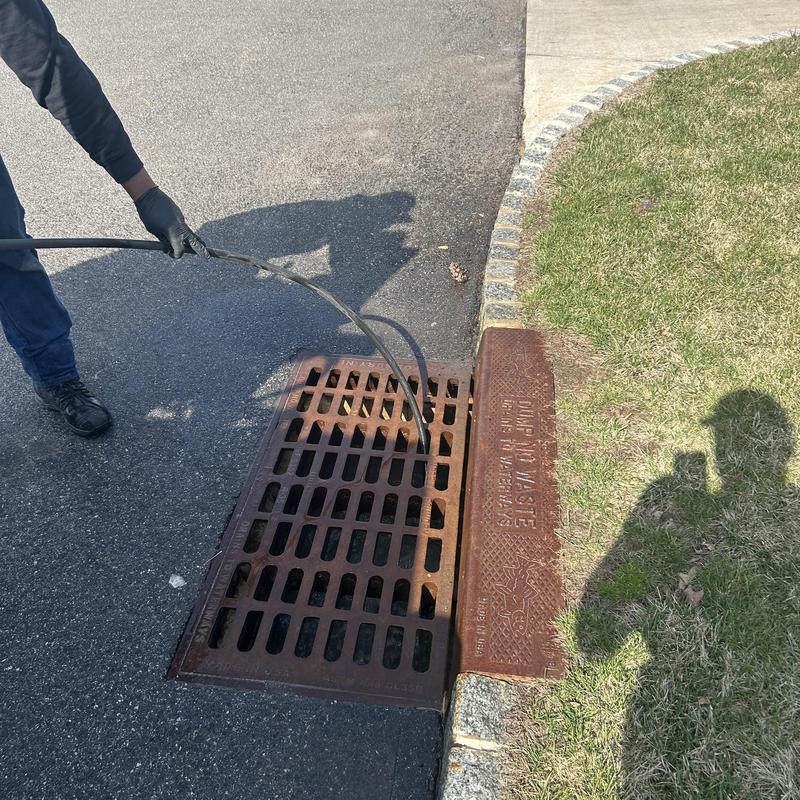 Storm drain cleaning with jetting hose in driveway Storm drain cleaning with jetting hose in driveway