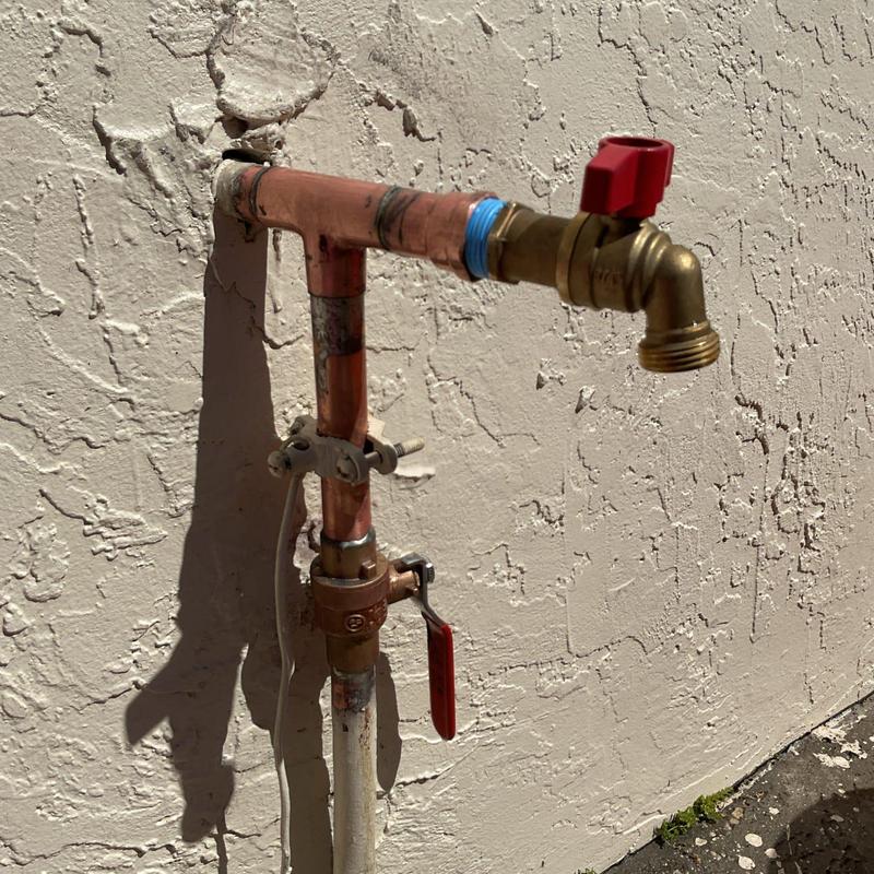 Quarter turn hose bib with copper piping on exterior wall