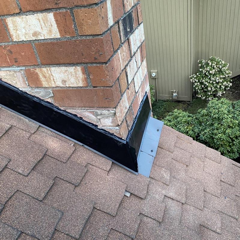 Chimney flashing on asphalt shingle roof with sealant