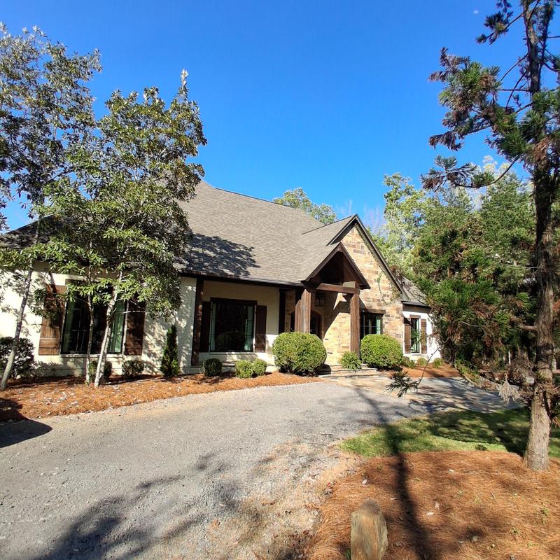 House exterior and driveway with trees and landscaping