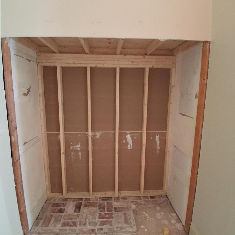 Sauna wall framing with exposed studs in closet space