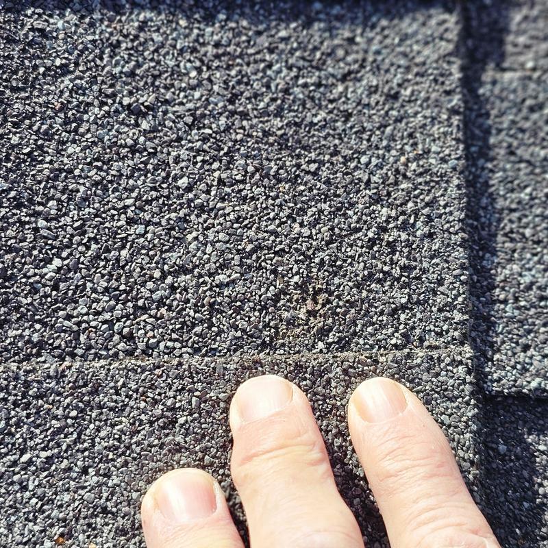 Asphalt roof shingles with hail damage close-up