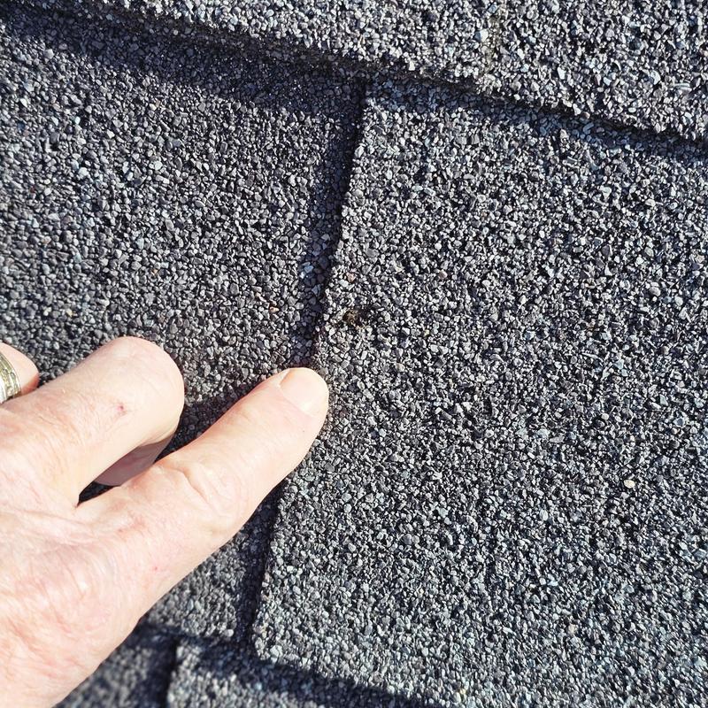 Roof shingles with hail damage close-up on corner