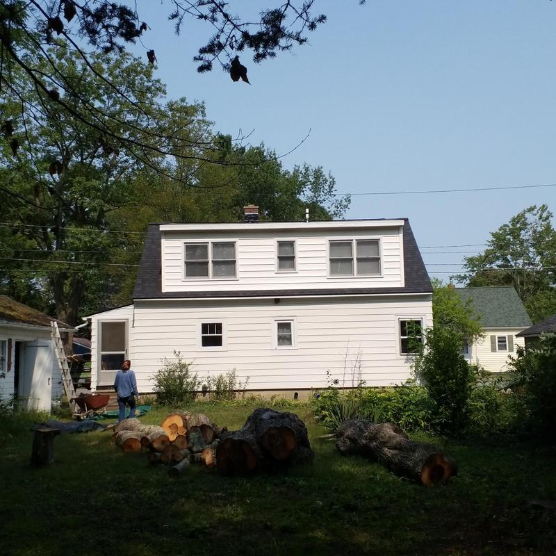 Asphalt shingle roof on two-story white house