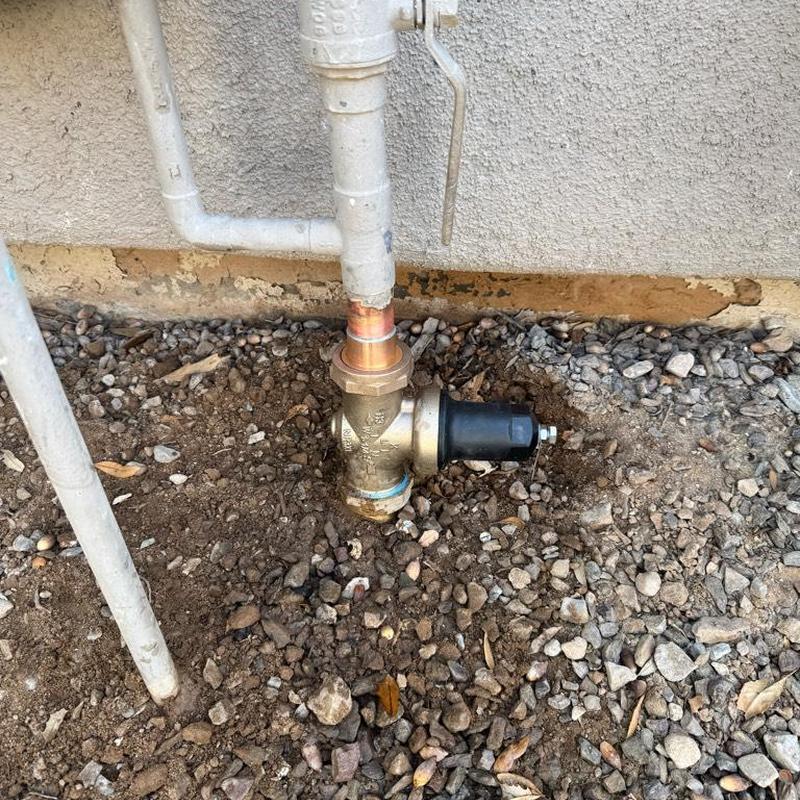 Pressure regulating valve on copper water riser outdoors