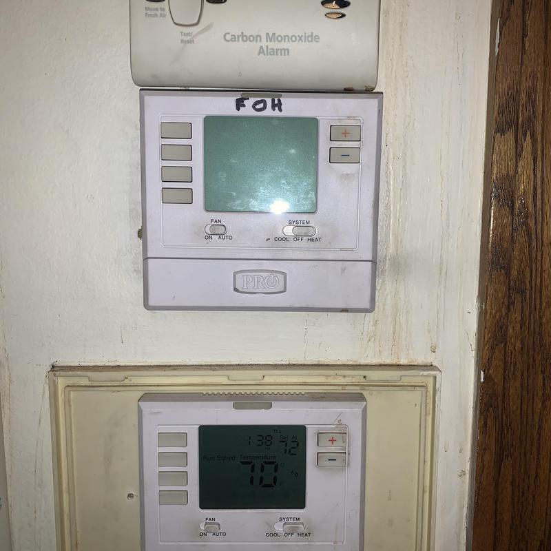 Thermostat units on interior wall with carbon monoxide alarm above
