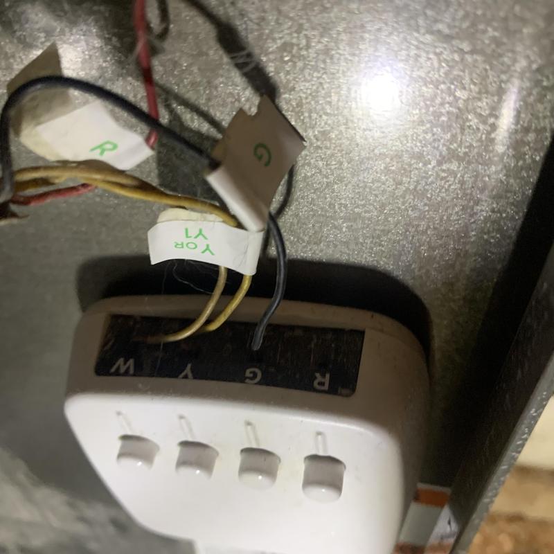 Smart thermostat wiring with labeled HVAC wires in panel