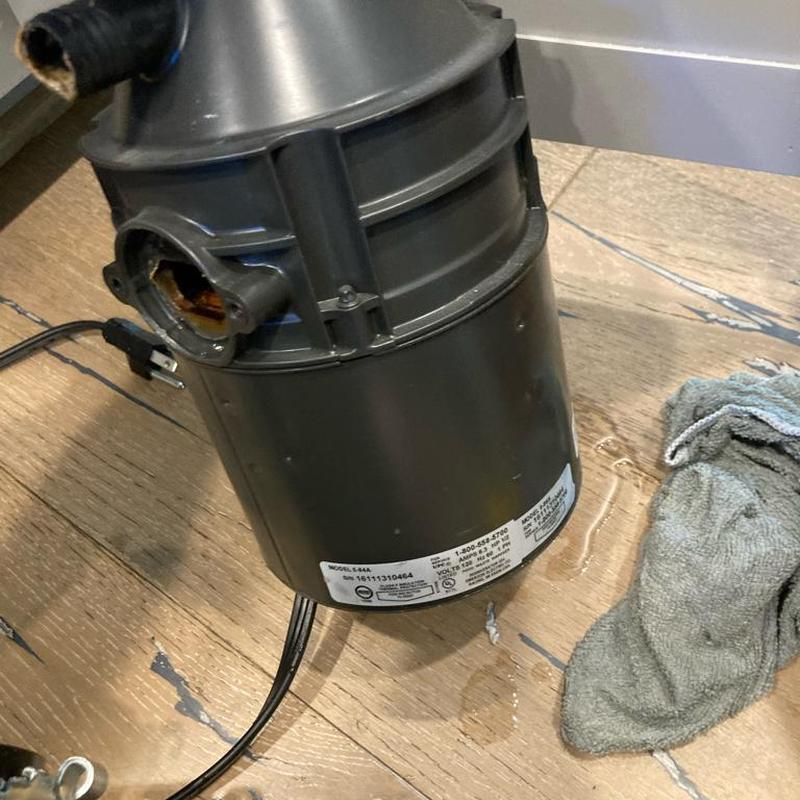 Garbage disposal unit removed on wooden floor