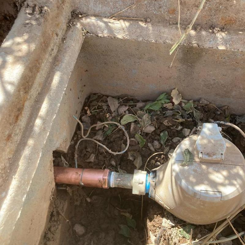 Copper main water line with meter and fittings in dirt box