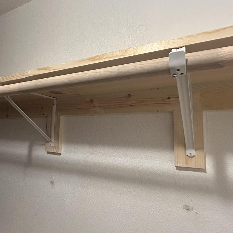 Custom wooden closet shelving with metal brackets