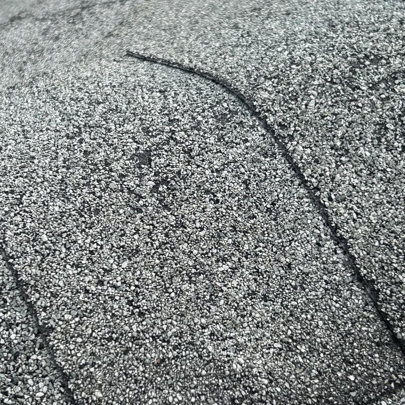 Asphalt shingle roof surface with visible wear and cracks