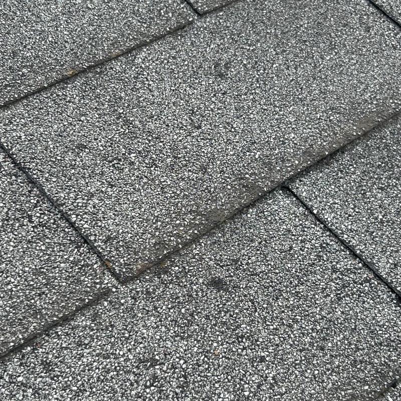 Asphalt roof shingles close-up showing granule wear