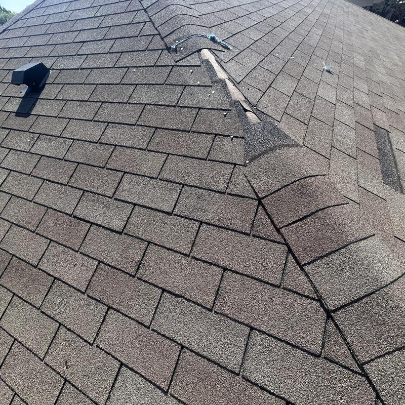 Asphalt shingle roof with vent and damaged ridge cap