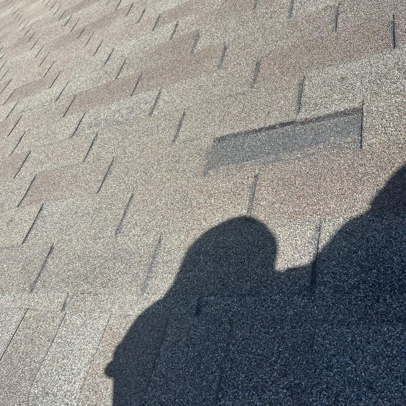 Asphalt shingle roof with damaged missing shingle section