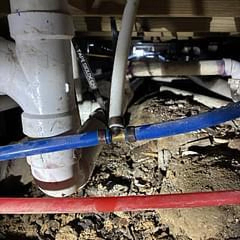 Blue water supply pipe with leak repair in crawlspace
