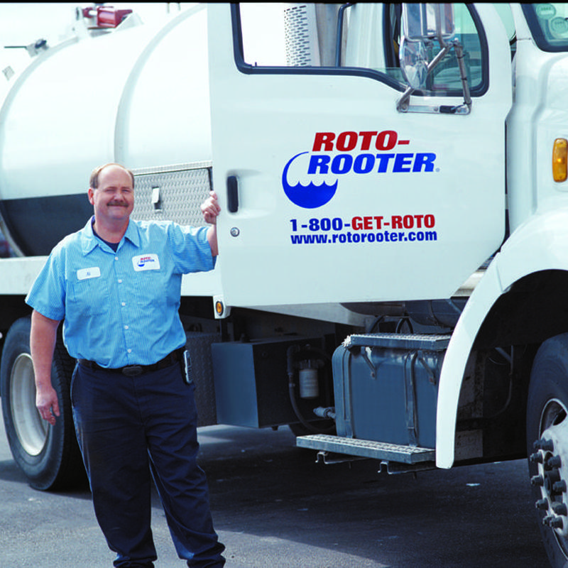 Septic tank pumping truck with technician in uniform