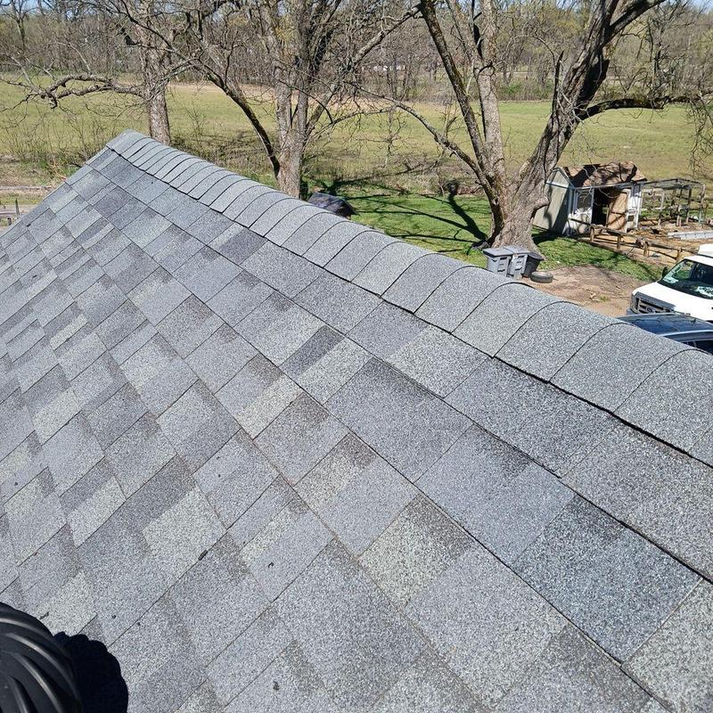 Asphalt shingle roof ridge with repaired sections