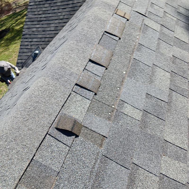 Asphalt shingle roof with lifted and missing shingles