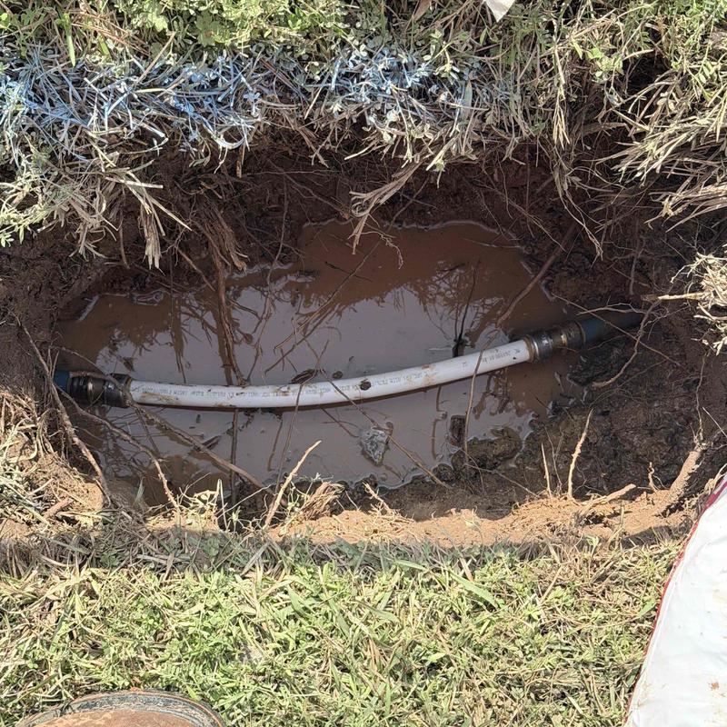 Underground water line with new pipe section in muddy hole