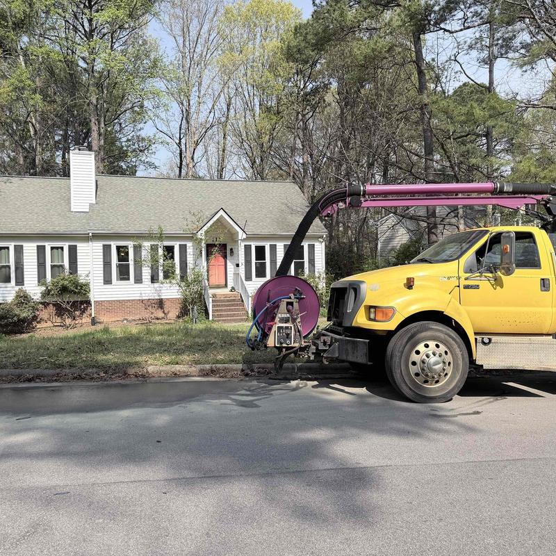 Underground water line with vacuum truck by house