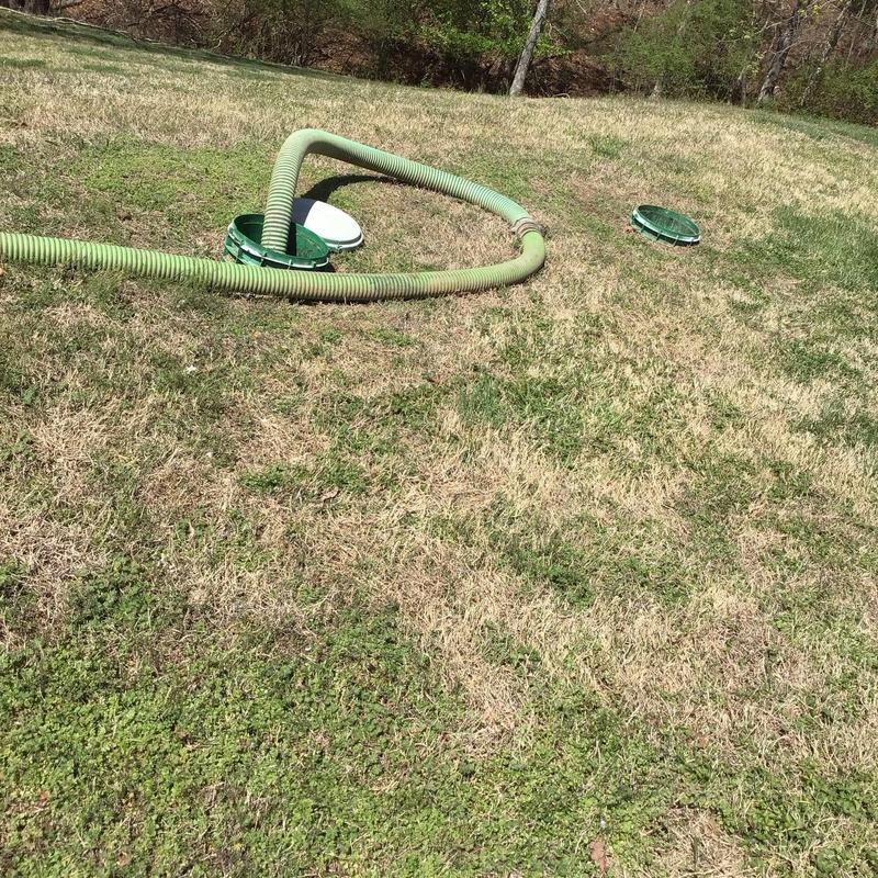 Septic tank with hose on grassy yard