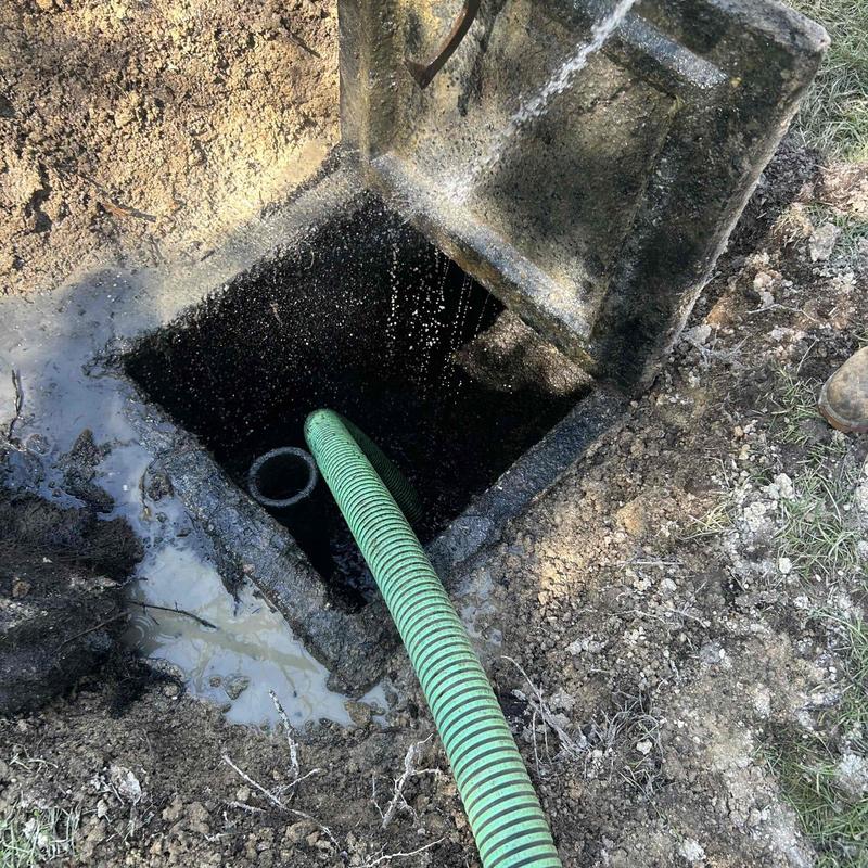 Septic tank with green vacuum hose pumping out