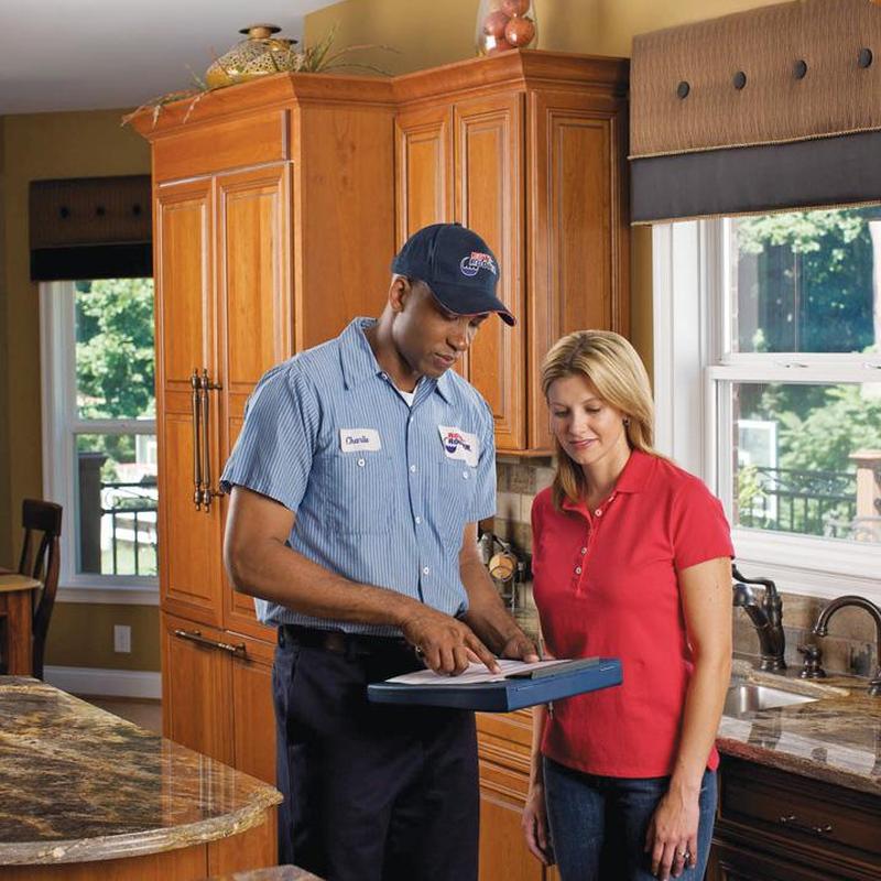 Kitchen sink plumbing inspection with technician and customer