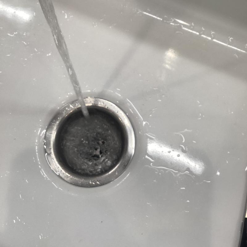 Sink drain with running water and minor clog buildup