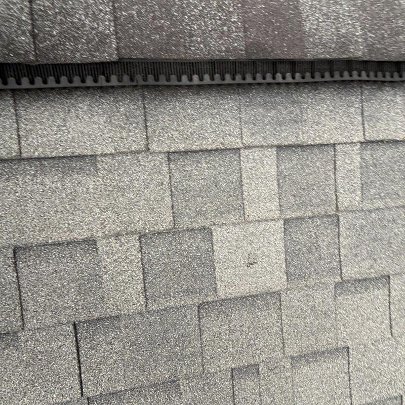 Asphalt roof shingles with ventilation ridge close-up