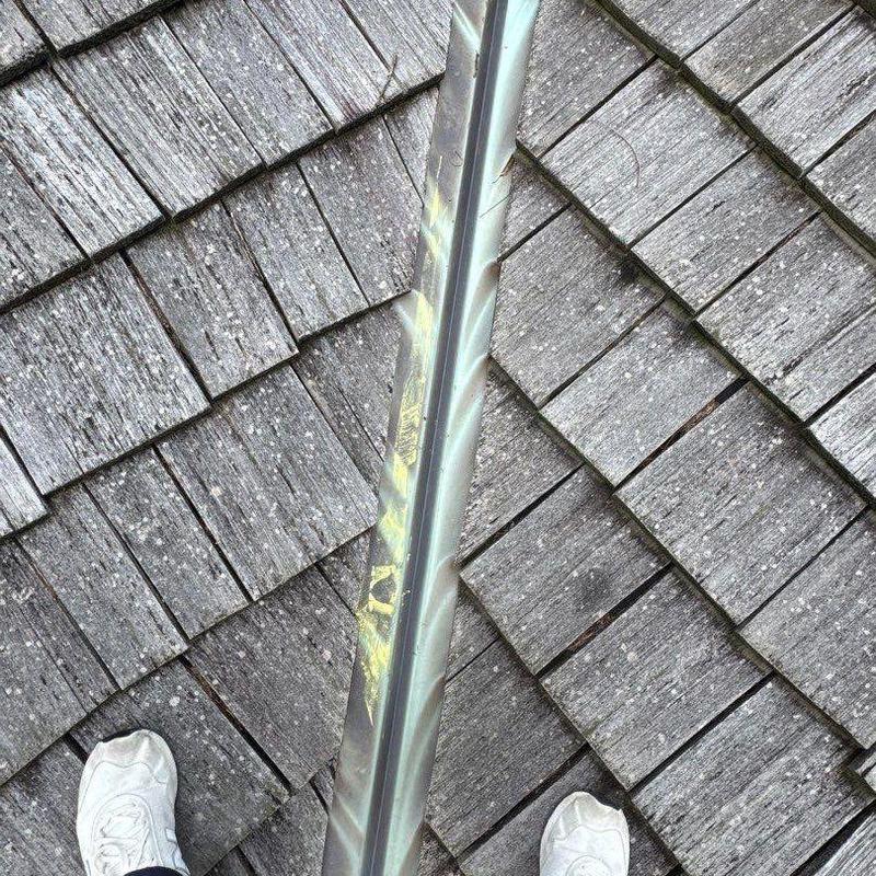 Metal roof valley flashing with hail damage and granule loss