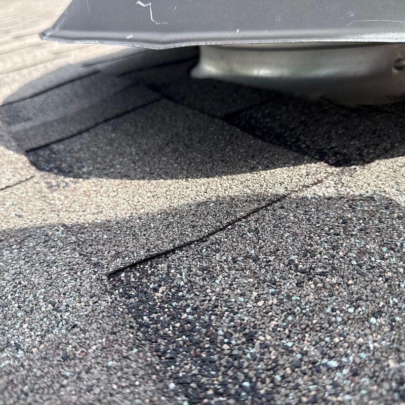 Asphalt shingles with cracking near metal flashing
