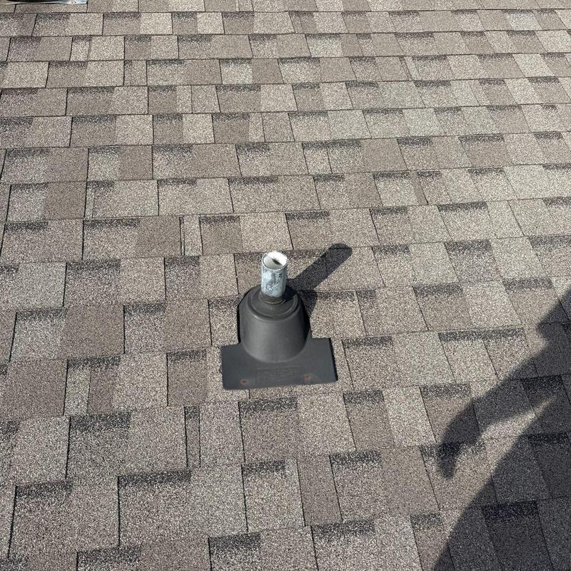 Roof vent flashing on asphalt shingle roof with hail damage